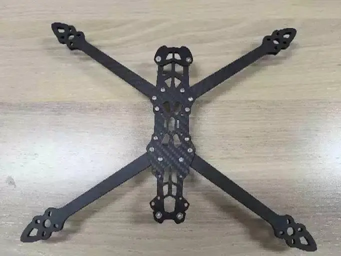 Carbon fibre quadcopter frame for an FPV drone on a light background